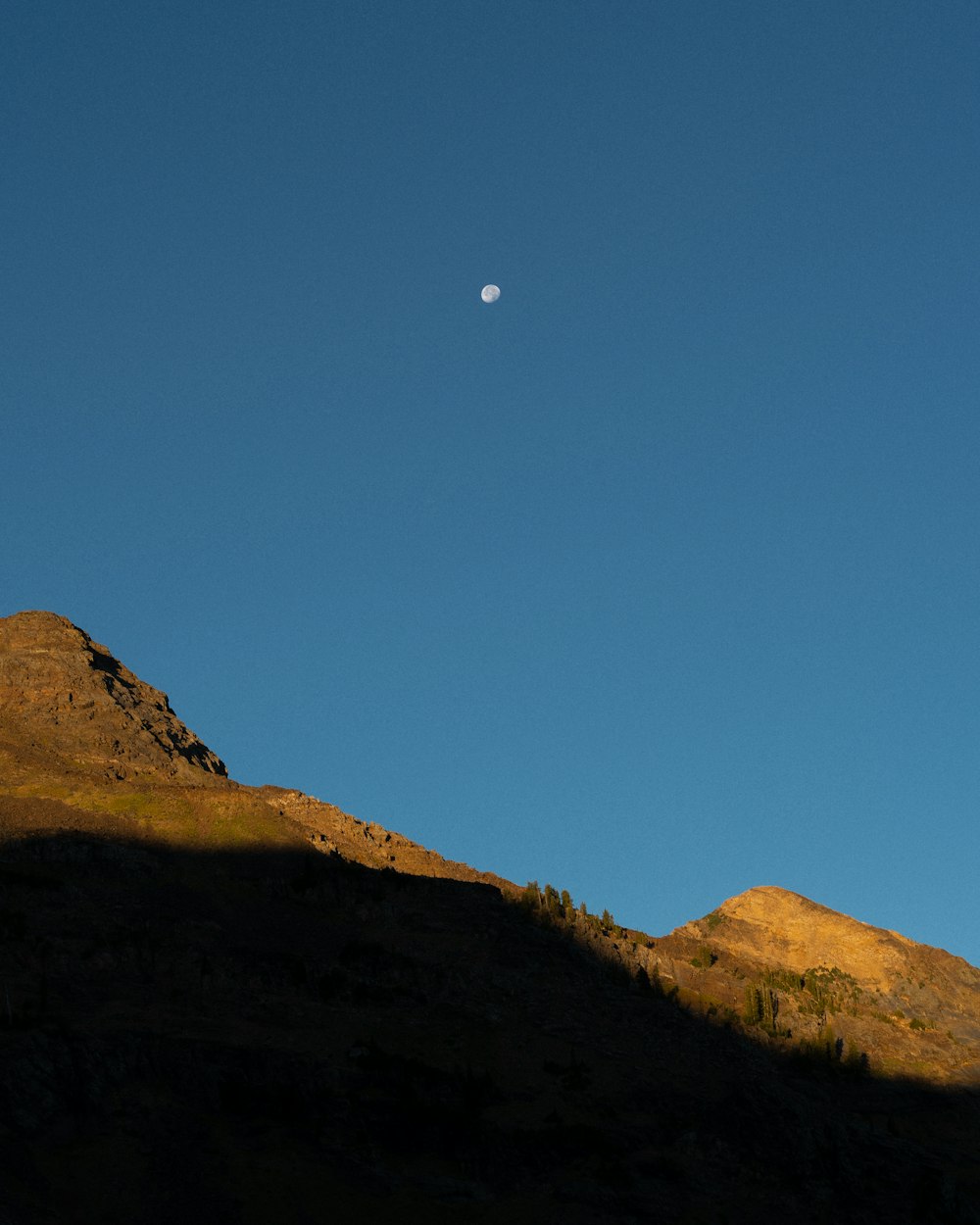 full moon over brown mountain