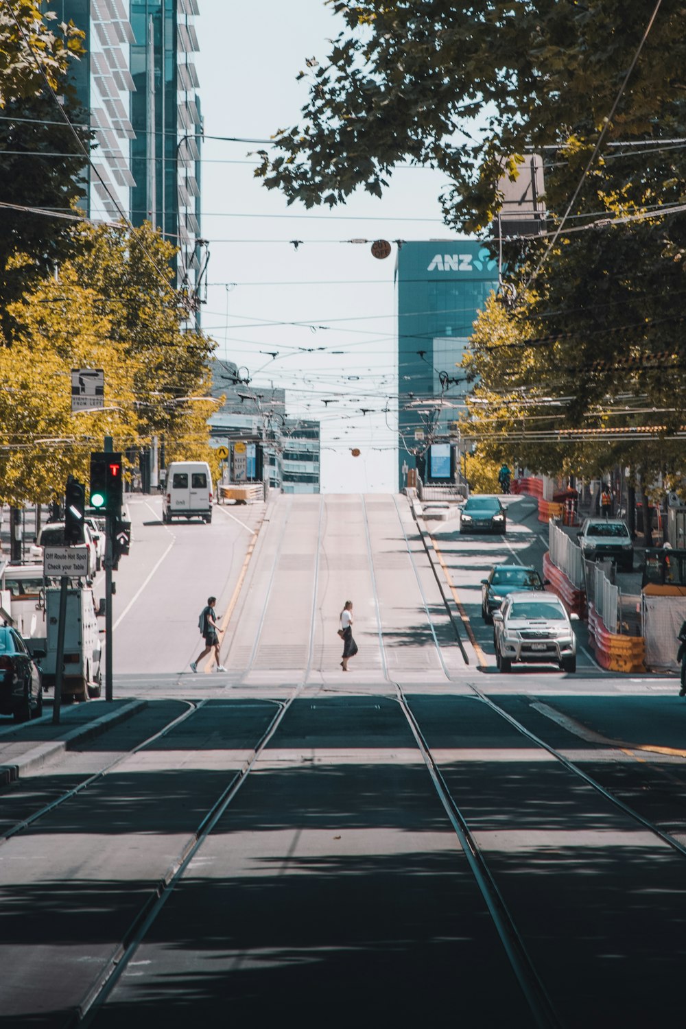 man in white jacket and black pants walking on pedestrian lane during daytime