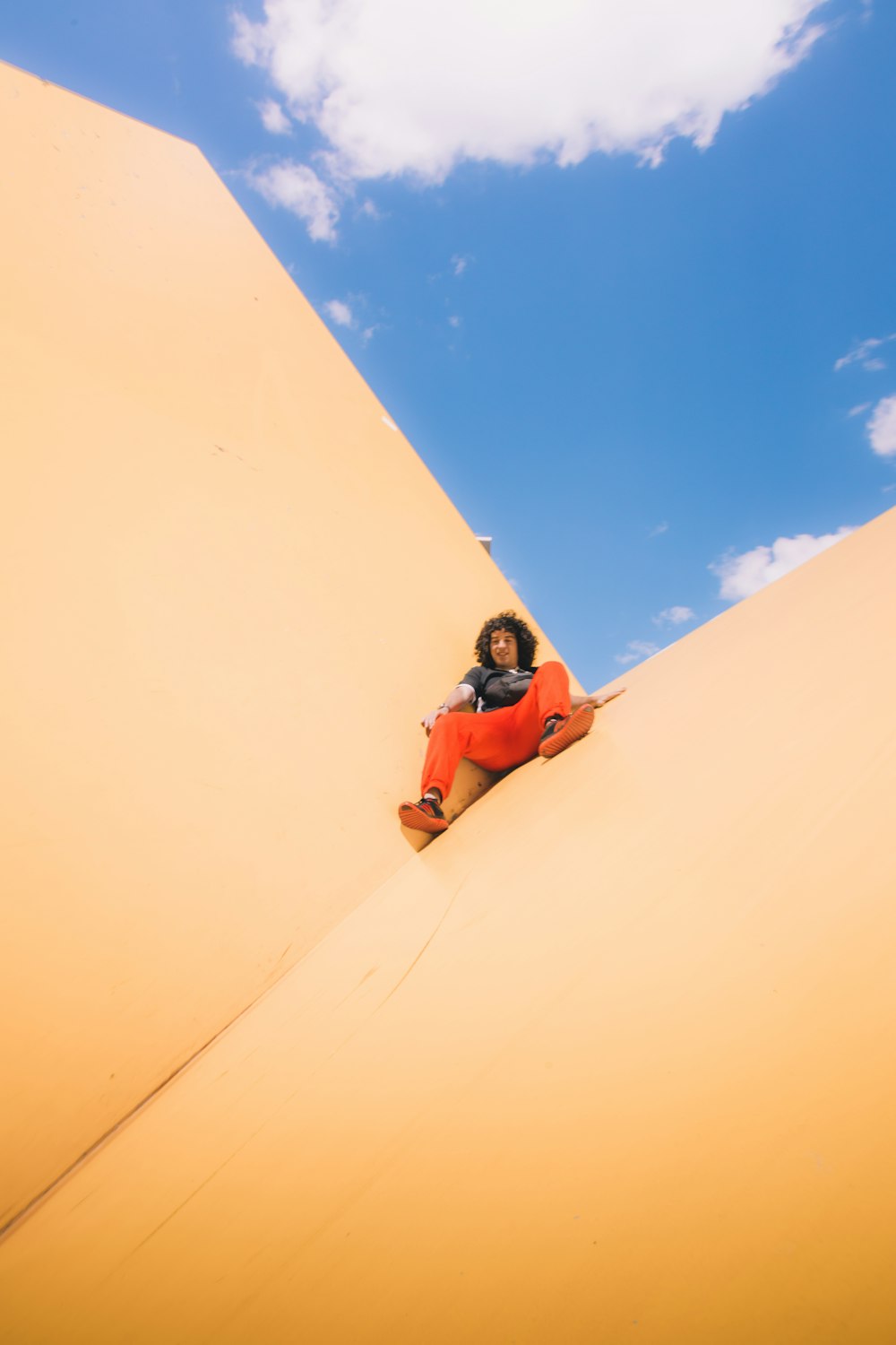 man in orange jacket and blue helmet riding on white snowboard during daytime