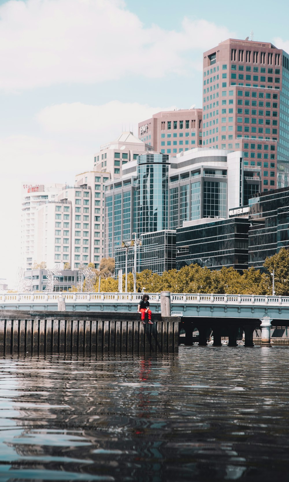 Personas caminando por el puente cerca de edificios de gran altura durante el día