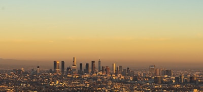 A panoramic view of São Paulo city skyline at sunset with warm orange and blue tones