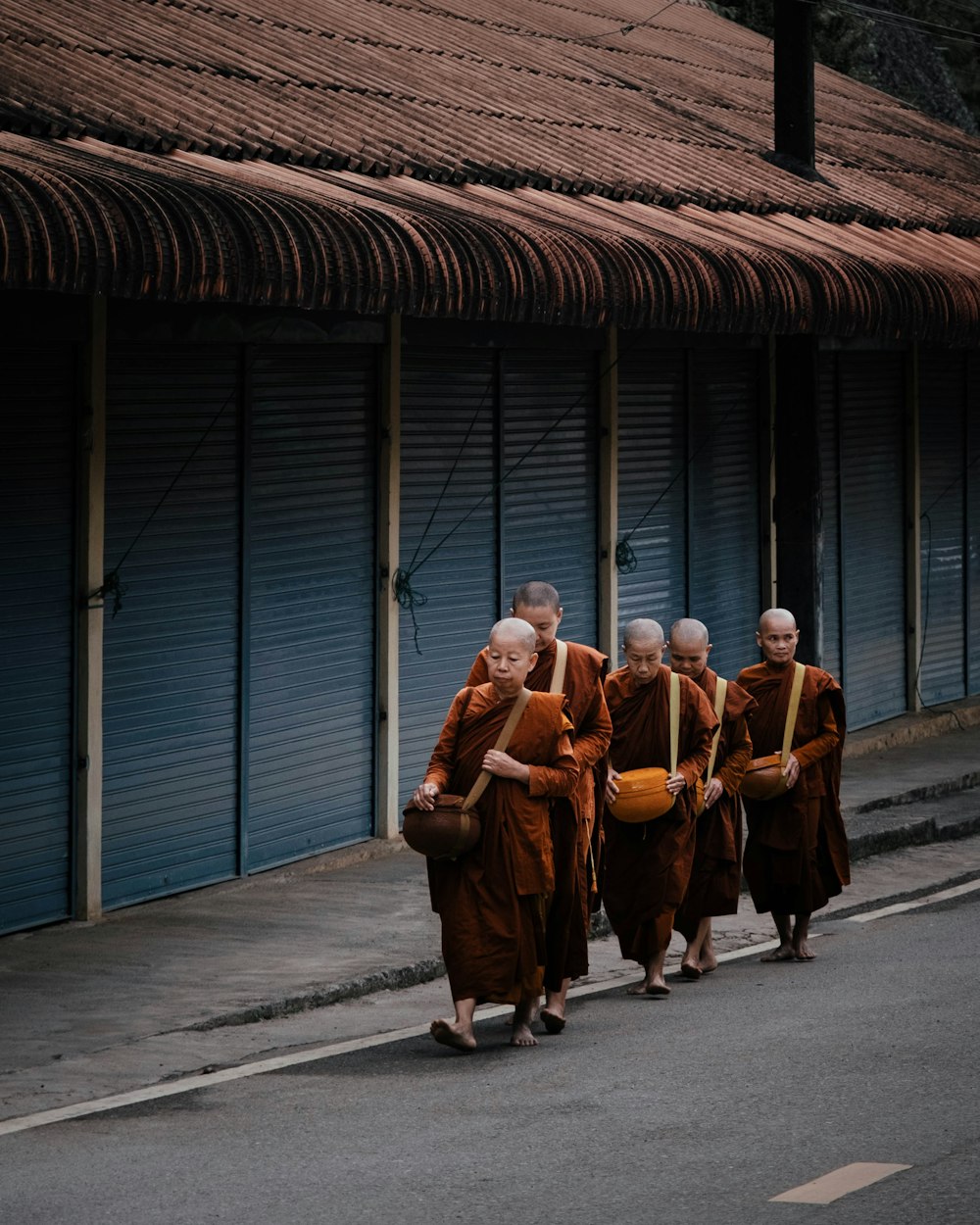 3 men and woman standing on sidewalk near blue sea during daytime