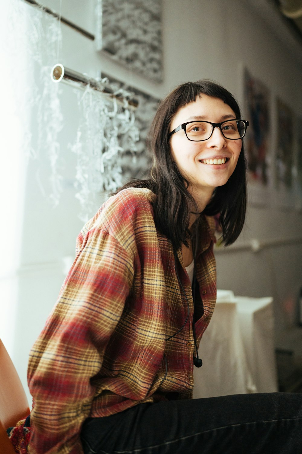 woman in red and black plaid button up shirt wearing black framed eyeglasses