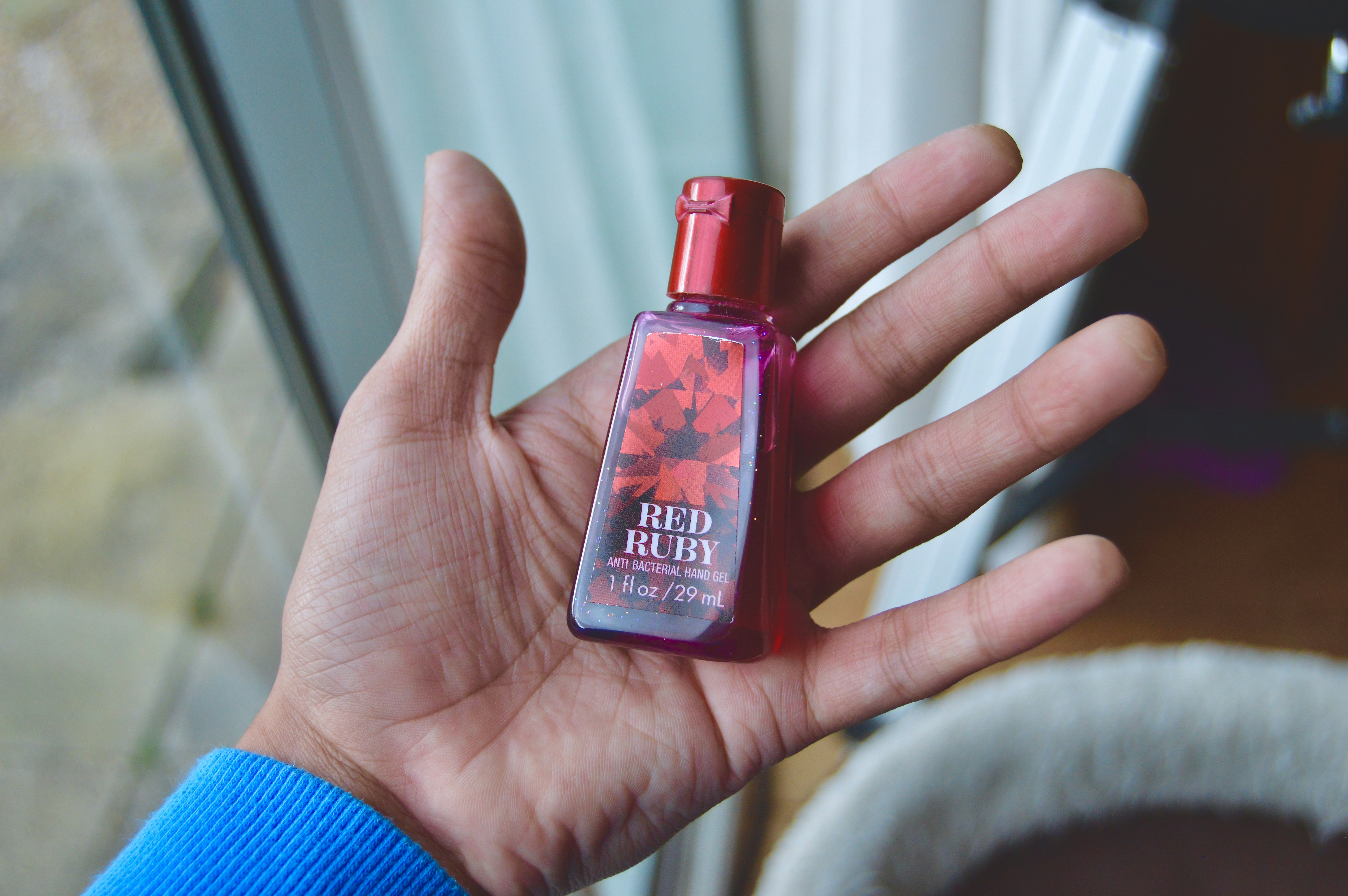 personne tenant du vernis à ongles rouge