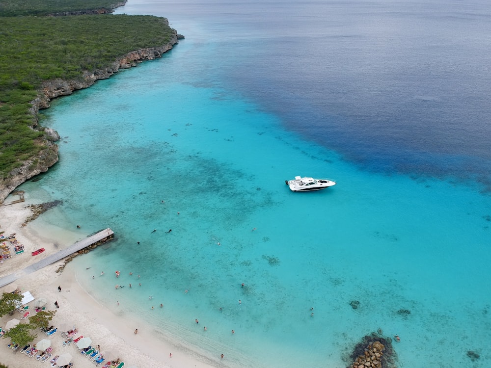 Bateau blanc sur l’eau de mer bleue pendant la journée