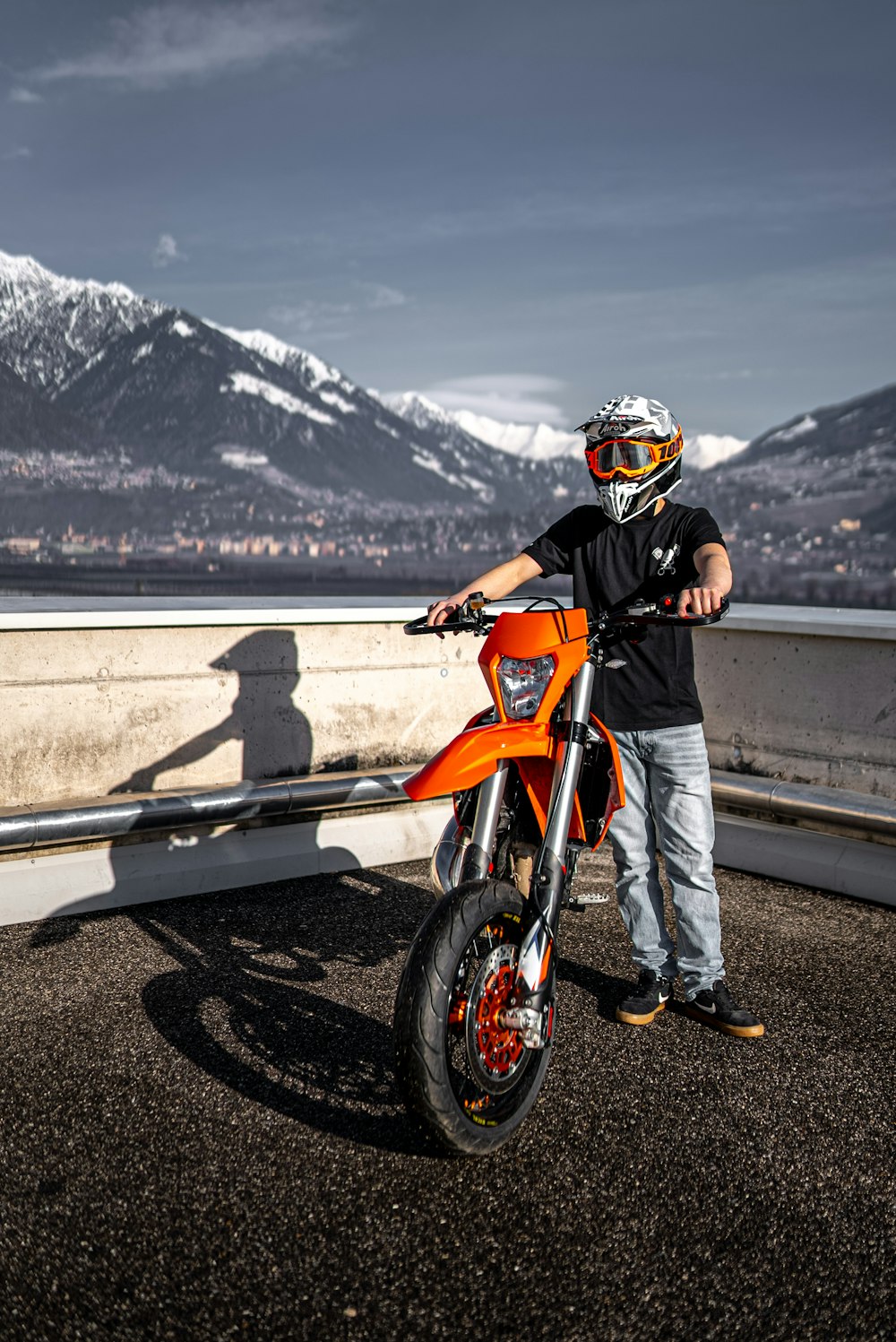 man in orange and black jacket riding orange motorcycle on road during daytime