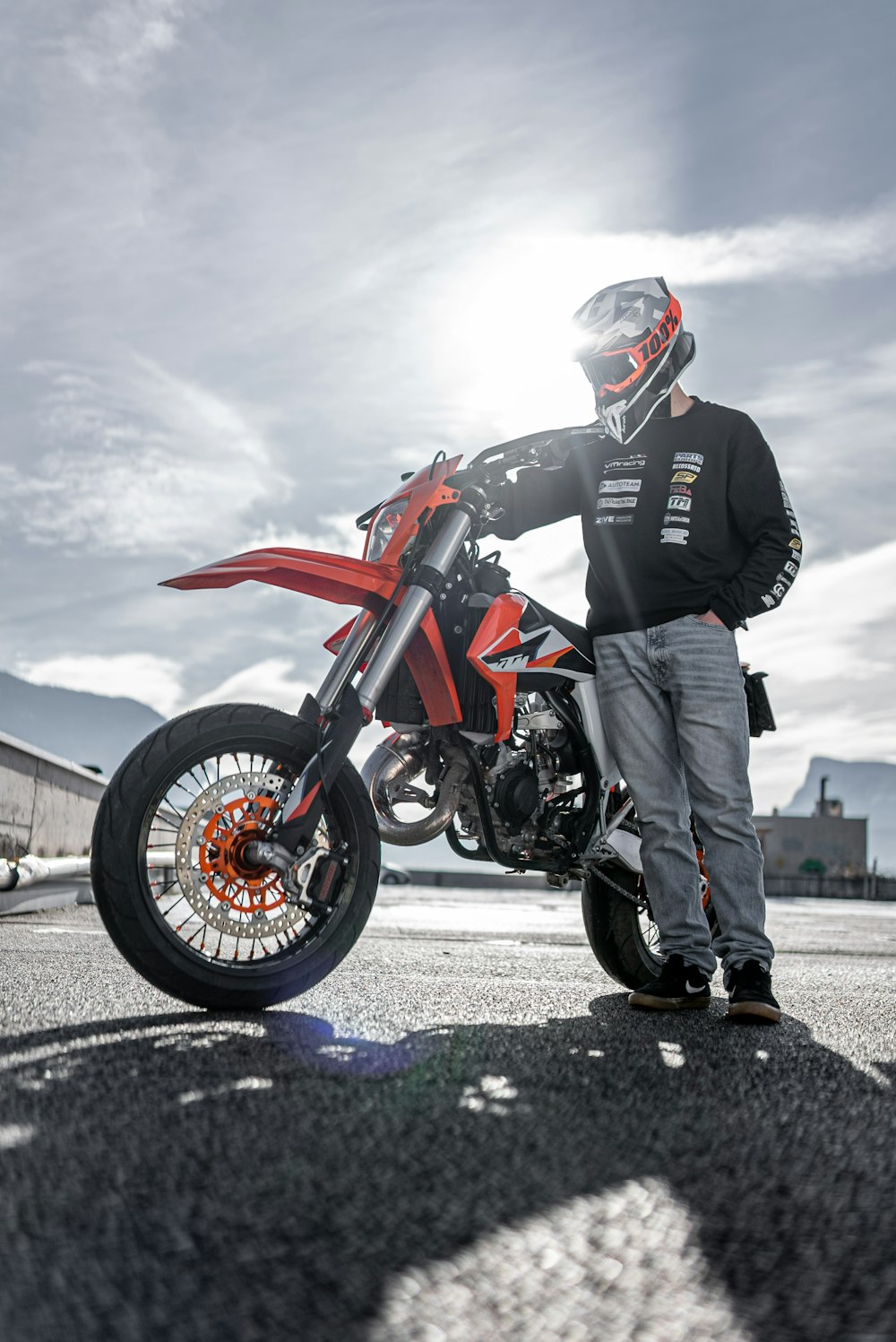 man in black jacket and gray pants wearing black helmet riding black and red sports bike