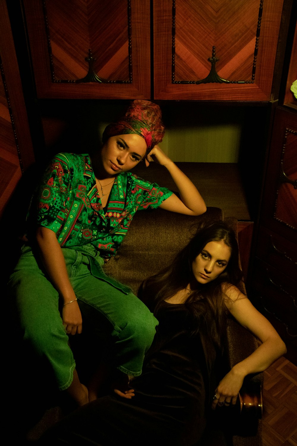 2 women in green and red dress sitting on floor