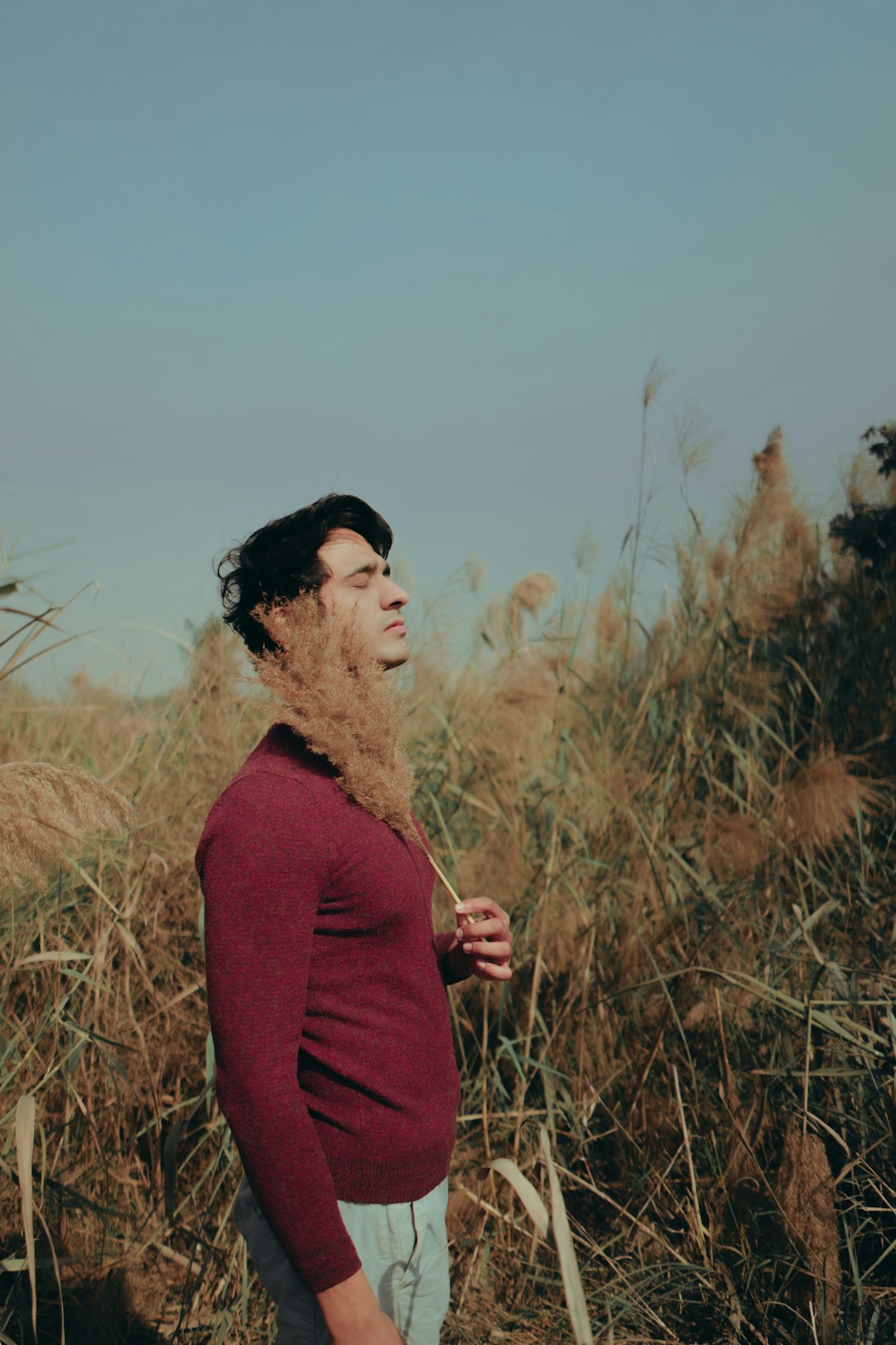 woman in red long sleeve shirt standing on brown grass field during daytime