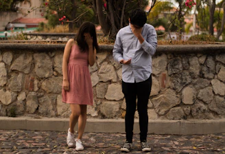 man and woman standing on gray concrete pathway during daytime