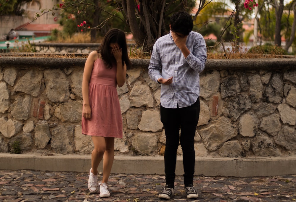 man and woman standing on gray concrete pathway during daytime