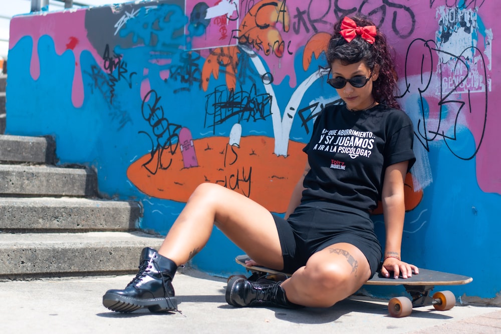 woman in black and white crew neck t-shirt and blue denim shorts sitting on brown