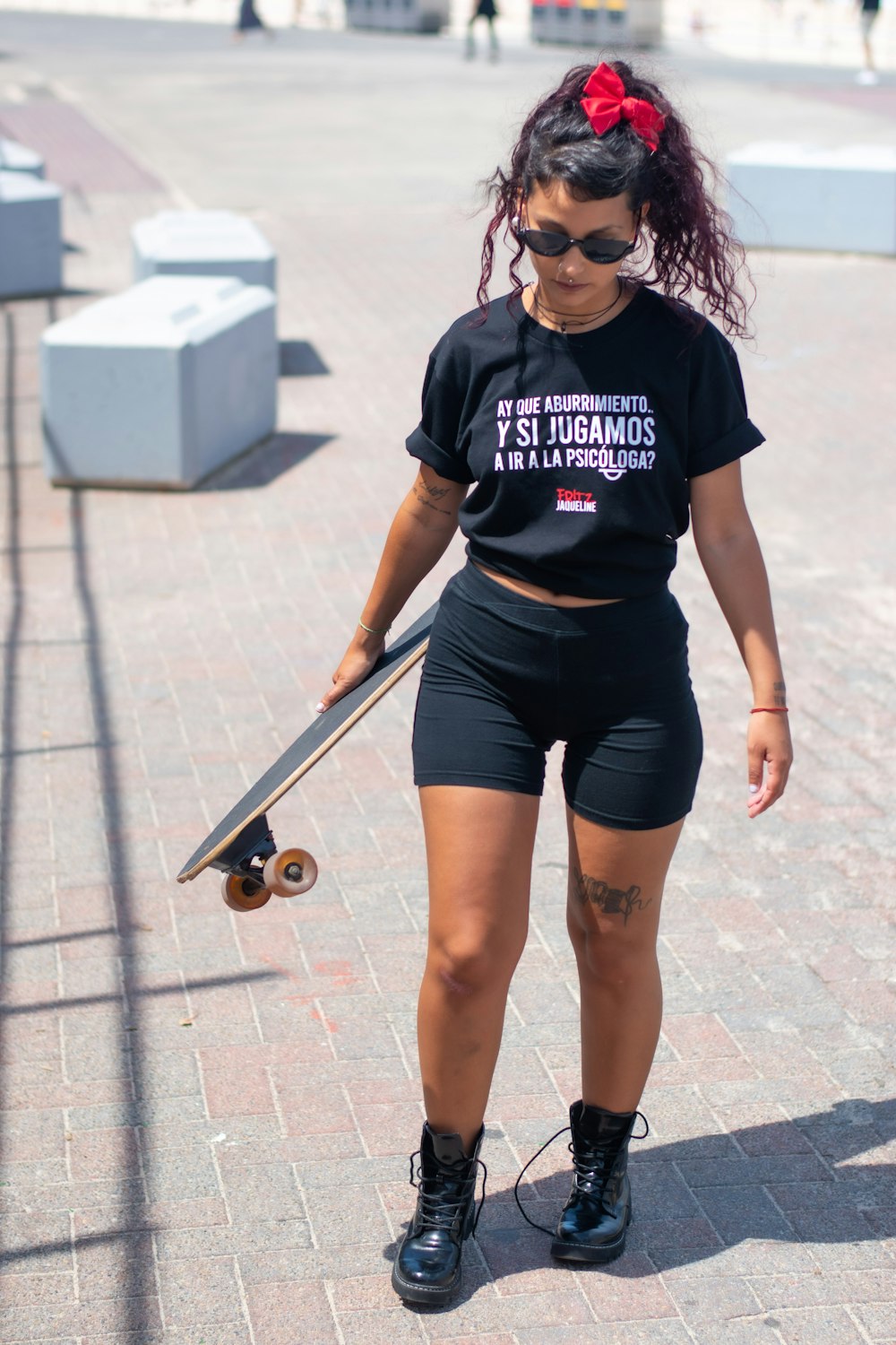 woman in black and white crew neck t-shirt and black shorts standing on gray concrete