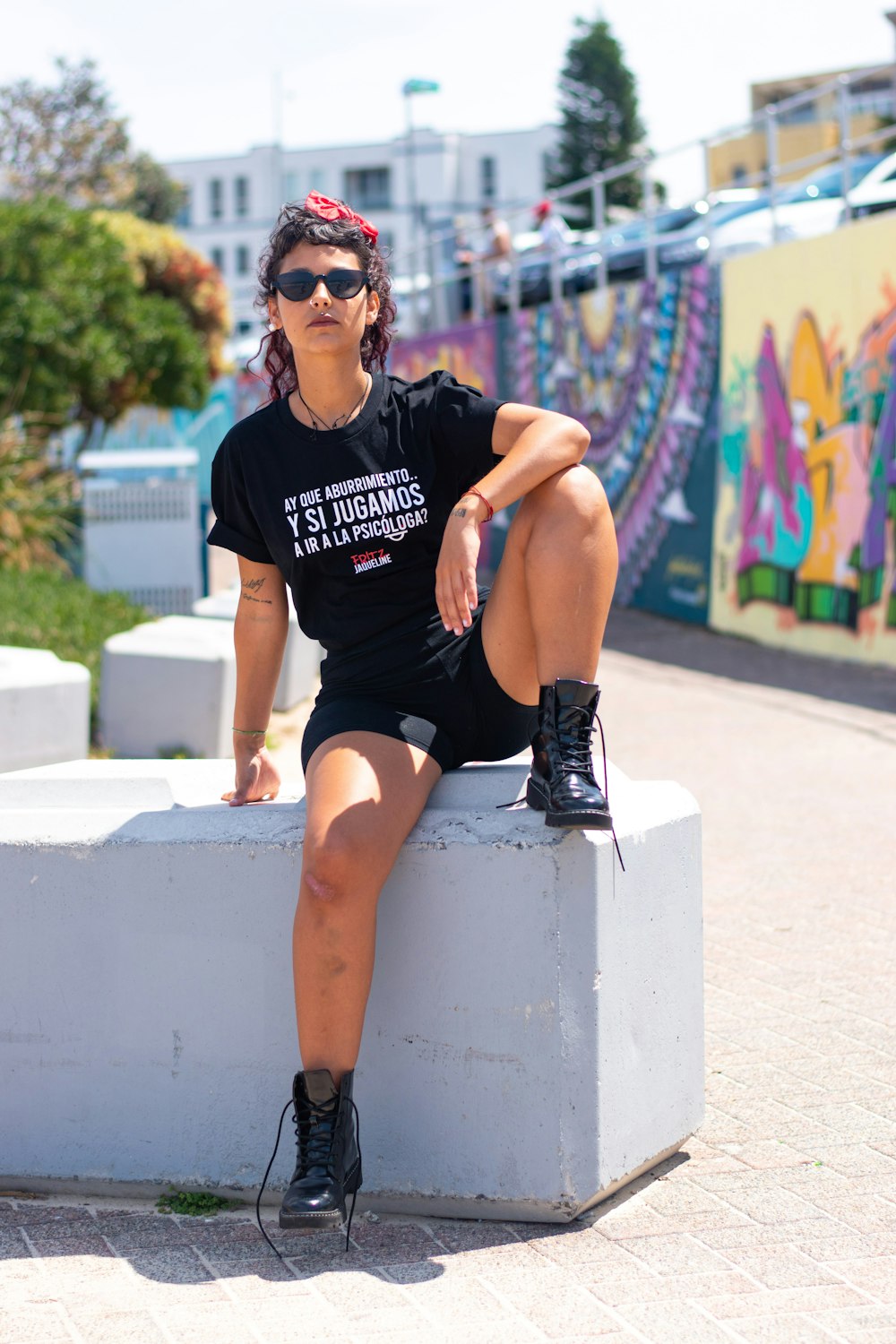 woman in black crew neck t-shirt and black shorts sitting on white concrete bench during