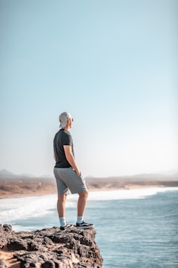 photography poses for men,how to photograph a man standing on top of a rock next to the ocean