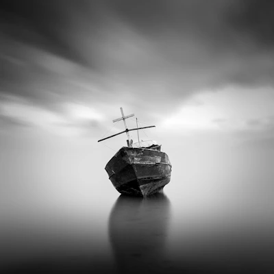 An ancient, weathered sailing ship silhouette drifting silently through foggy waters.