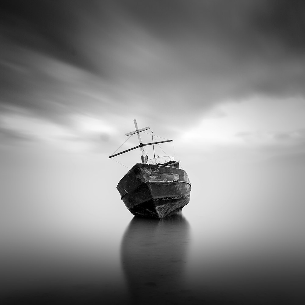 grayscale photo of sailboat on calm water