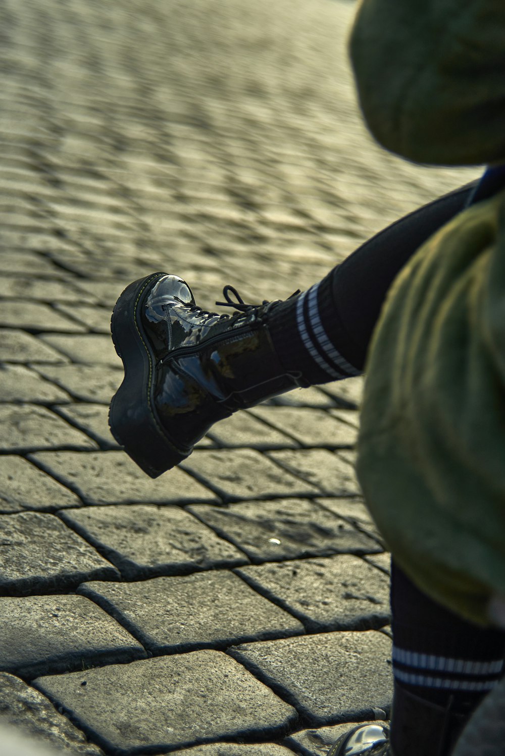 person in black pants and black nike sneakers