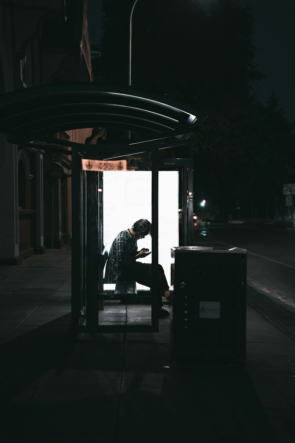 man in black jacket sitting on bench