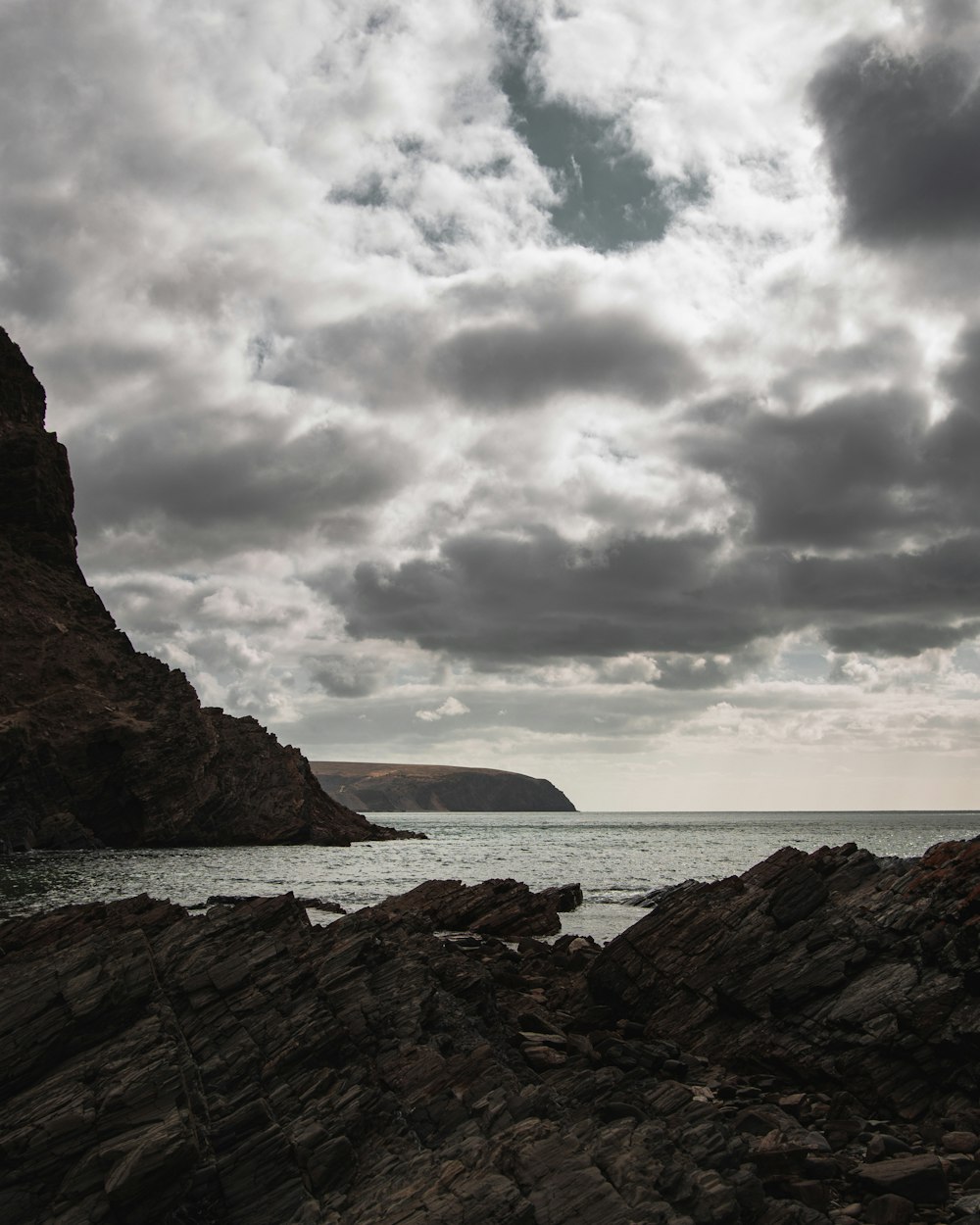 brown rock formation near body of water during daytime