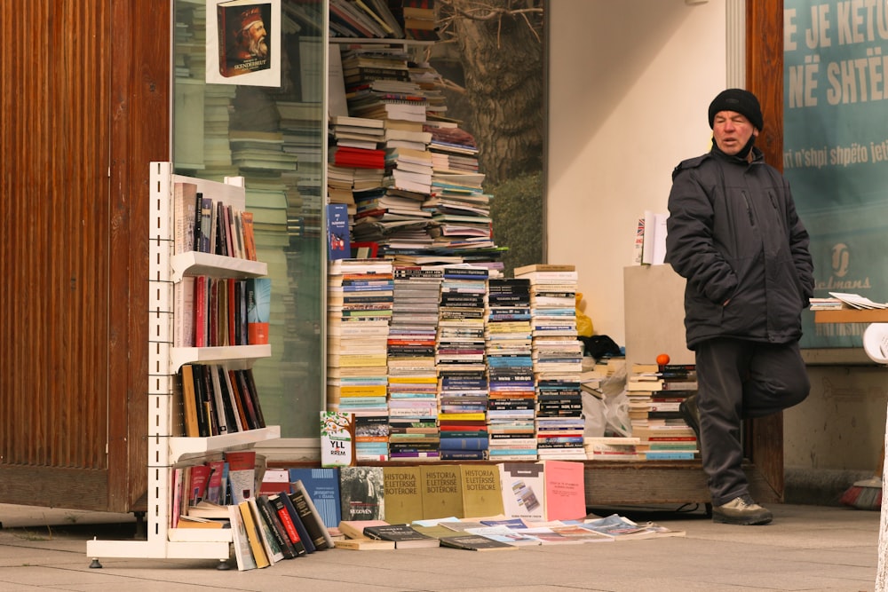 man in black jacket standing near books