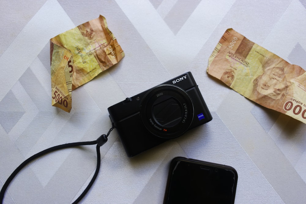 black nikon camera beside brown banknote