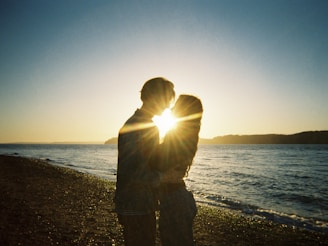A silhouette of a couple enjoying a sunset on the beach.