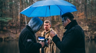 man in black jacket holding blue umbrella during daytime