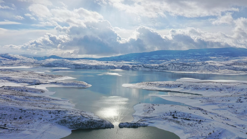 body of water under white clouds during daytime