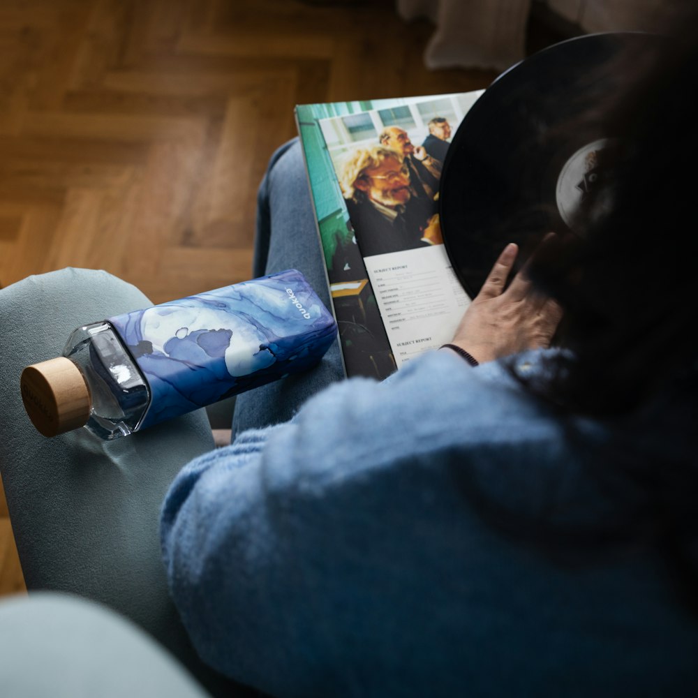 white and blue plastic bottle on persons lap