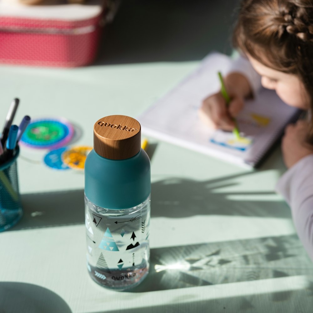 blue and white plastic bottle on white table