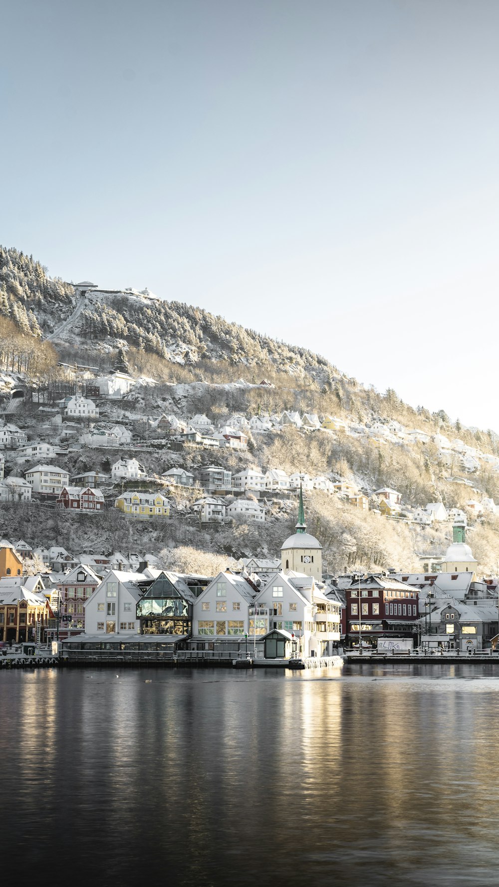 white and brown concrete buildings near brown mountain under blue sky during daytime