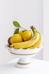 yellow banana fruit on white ceramic bowl