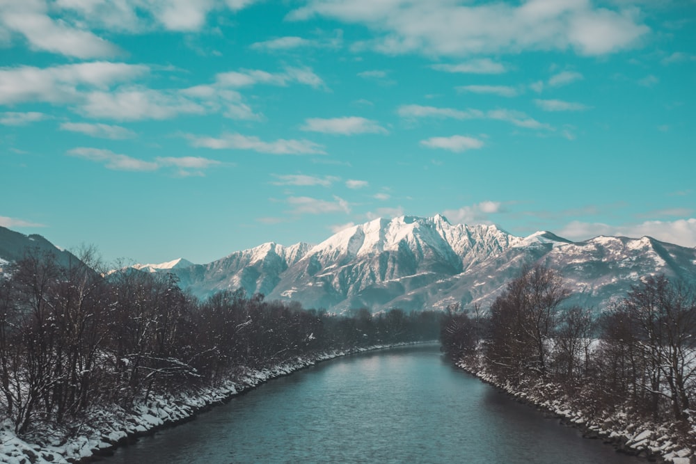 snow covered mountain near body of water during daytime