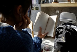woman in blue sweater reading book