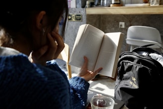 woman in blue sweater reading book