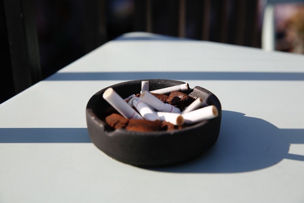 mozziconi di sigaretta su posacenere in ceramica nera