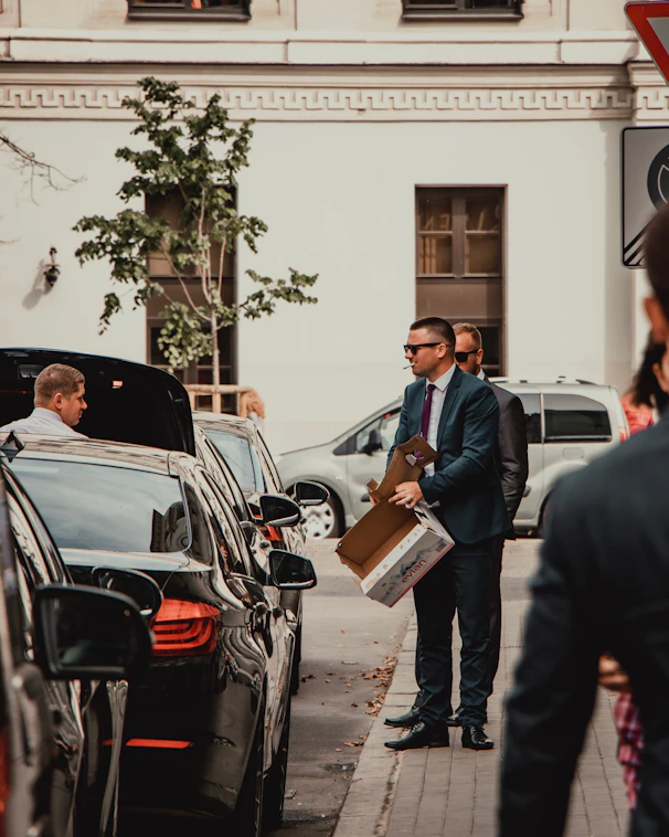 man in black suit standing beside man in blue suit