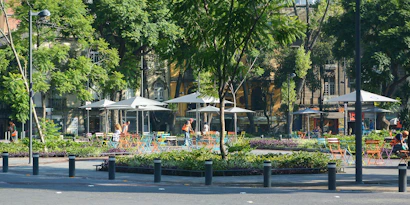 A vibrant urban scene showing people enjoying a stylish outdoor lounge area with smooth transitions between transit and relaxation spaces.