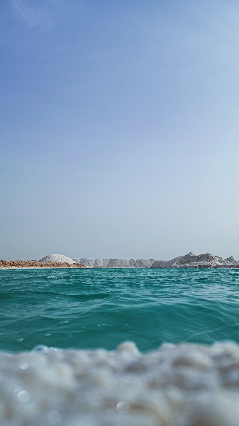 body of water near mountain during daytime