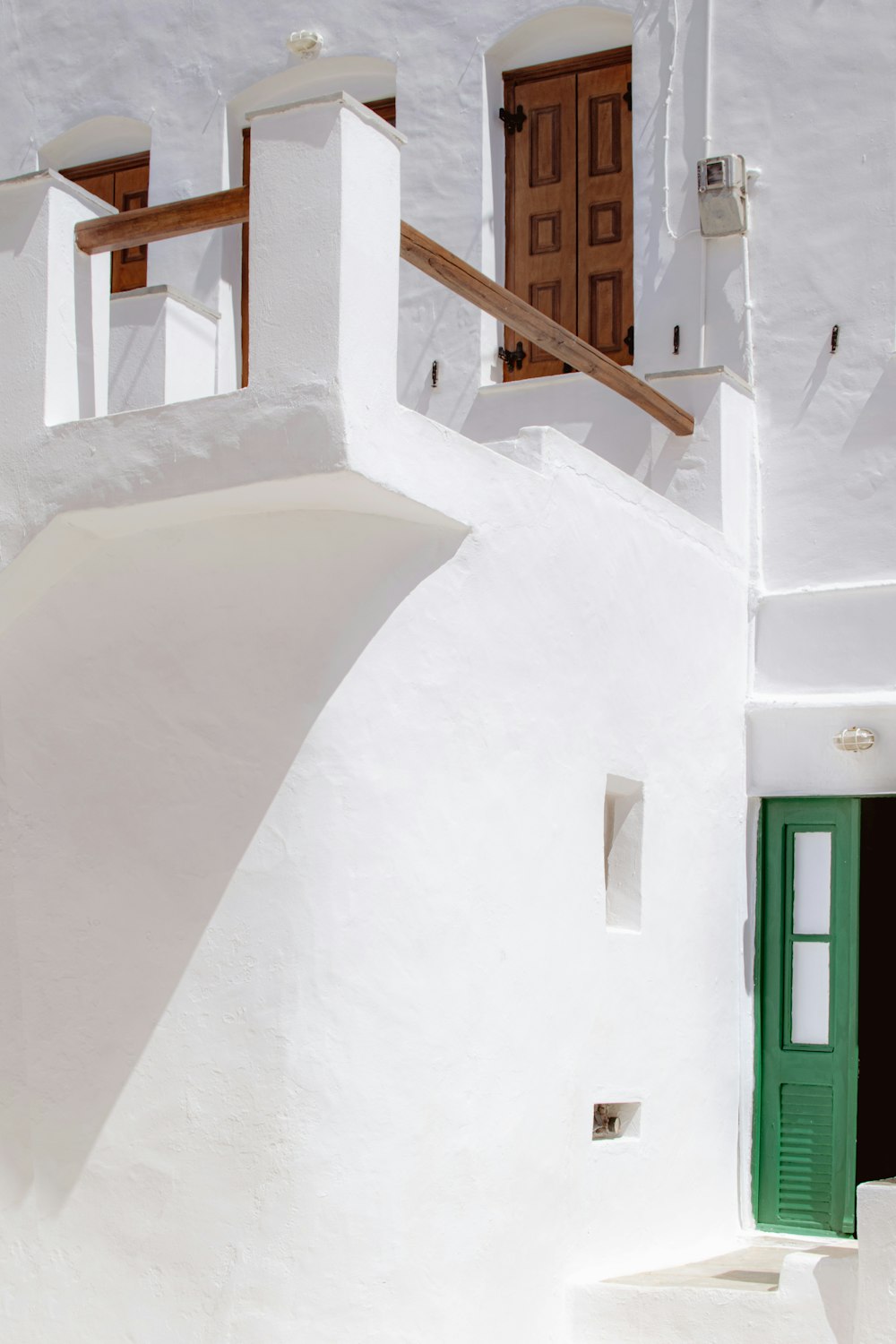 white concrete building with green wooden door