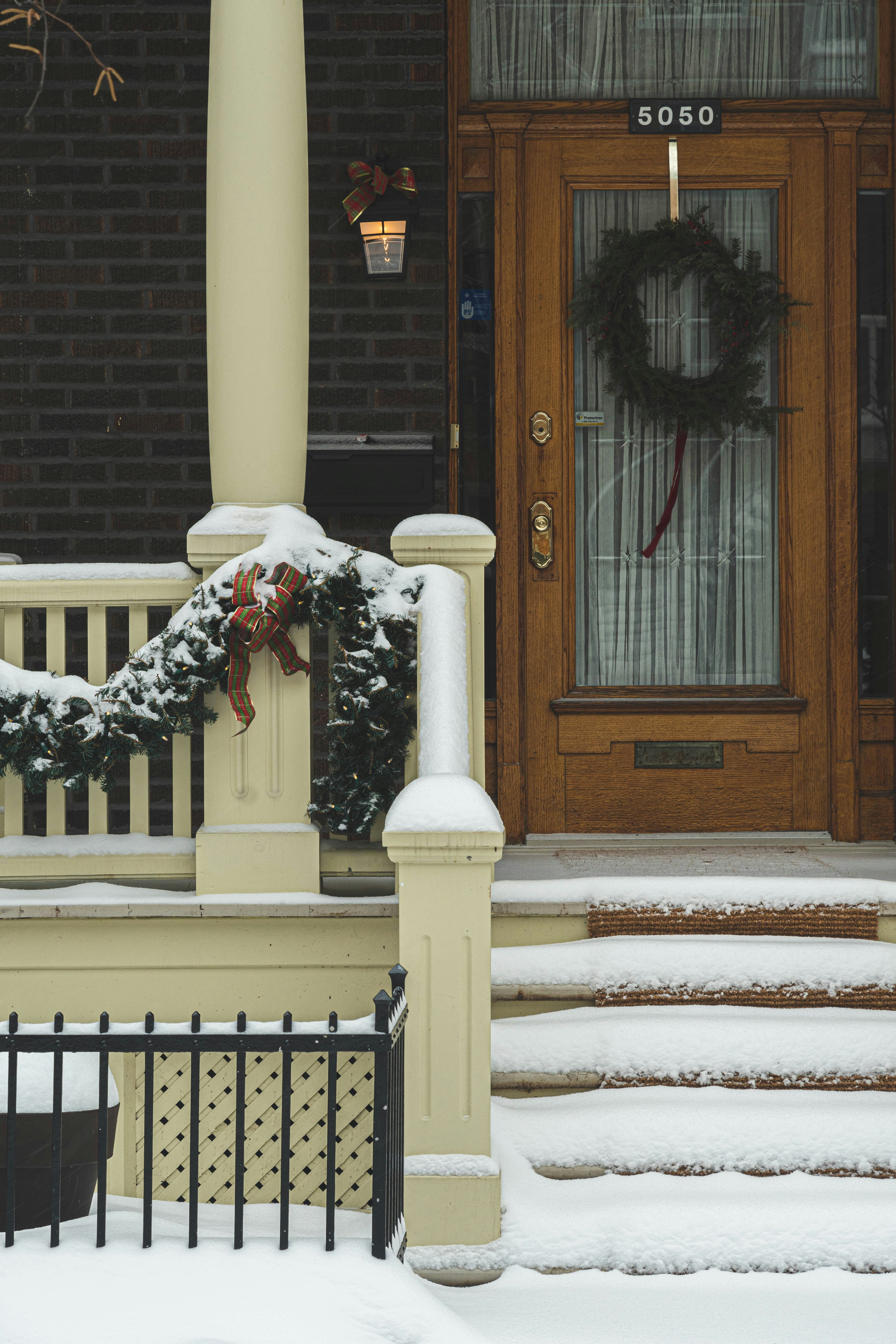 braune Holztür mit weißem und schwarzem Blumenkranz