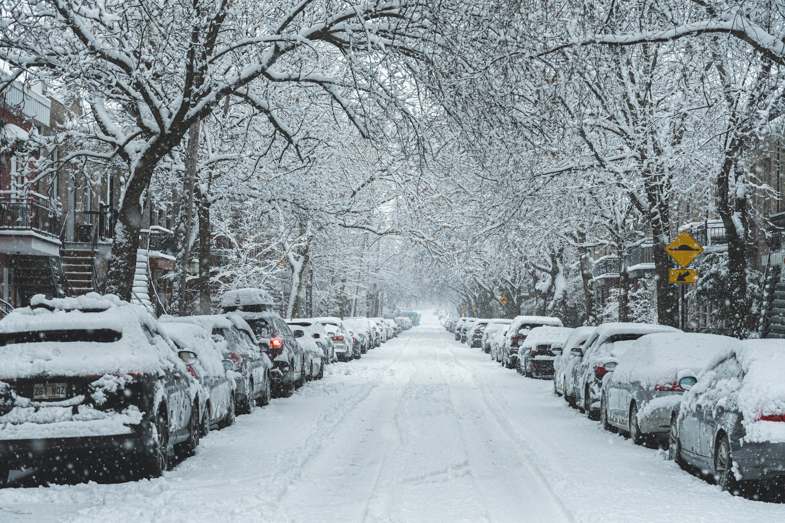 Parked cars line a snow-covered Montréal street