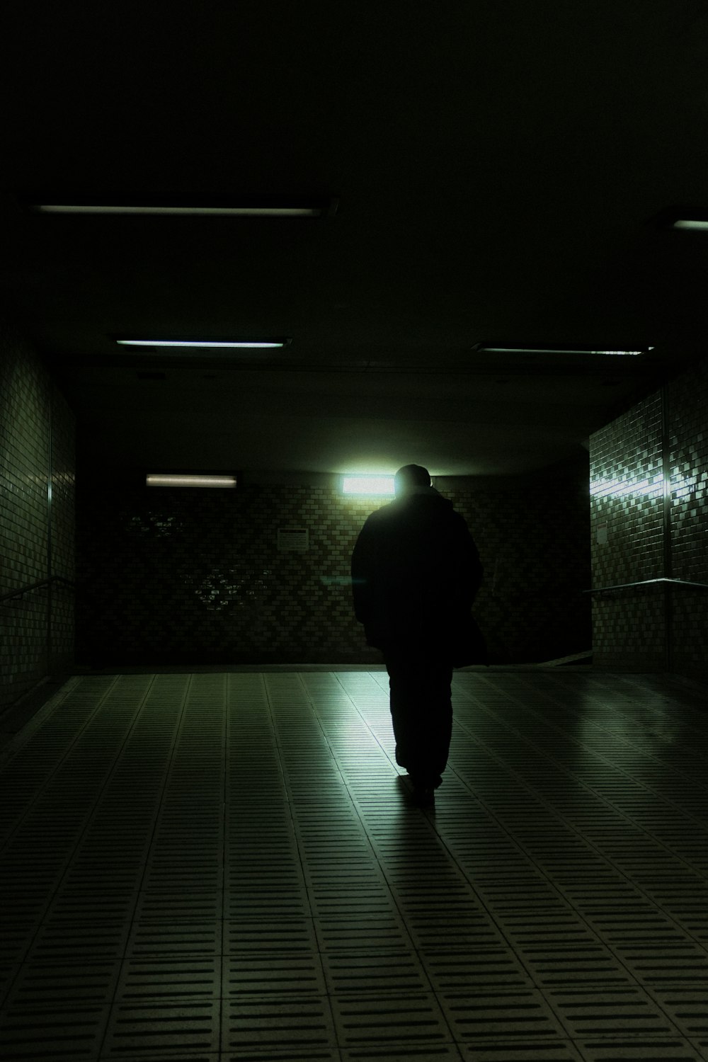 a man is walking in a dark tunnel