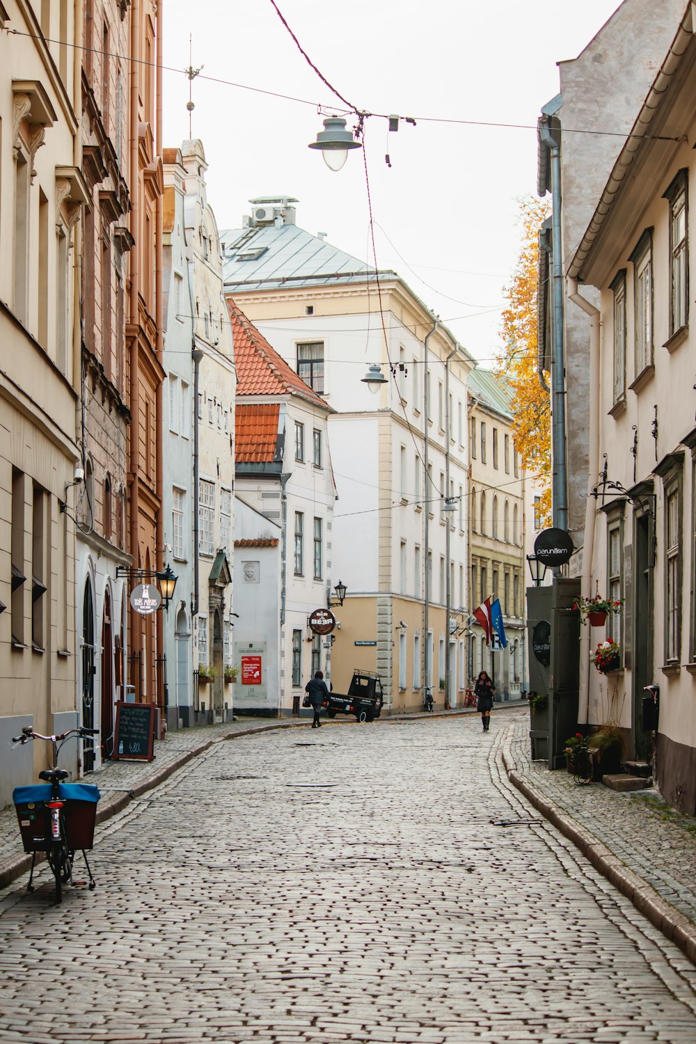 cars parked on sidewalk beside buildings during daytime