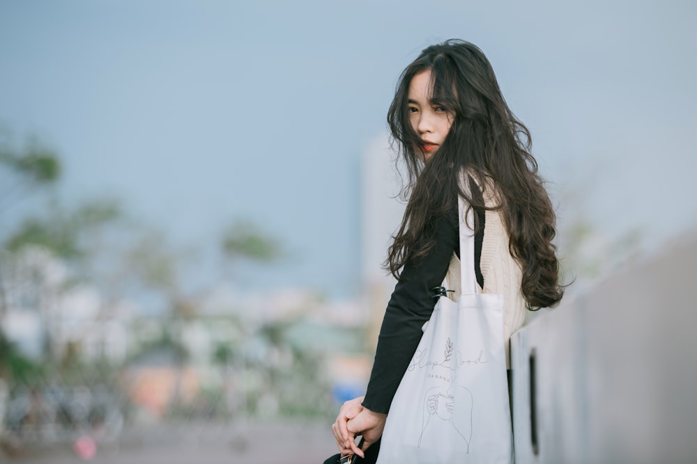 woman in white long sleeve dress standing on gray concrete floor during daytime