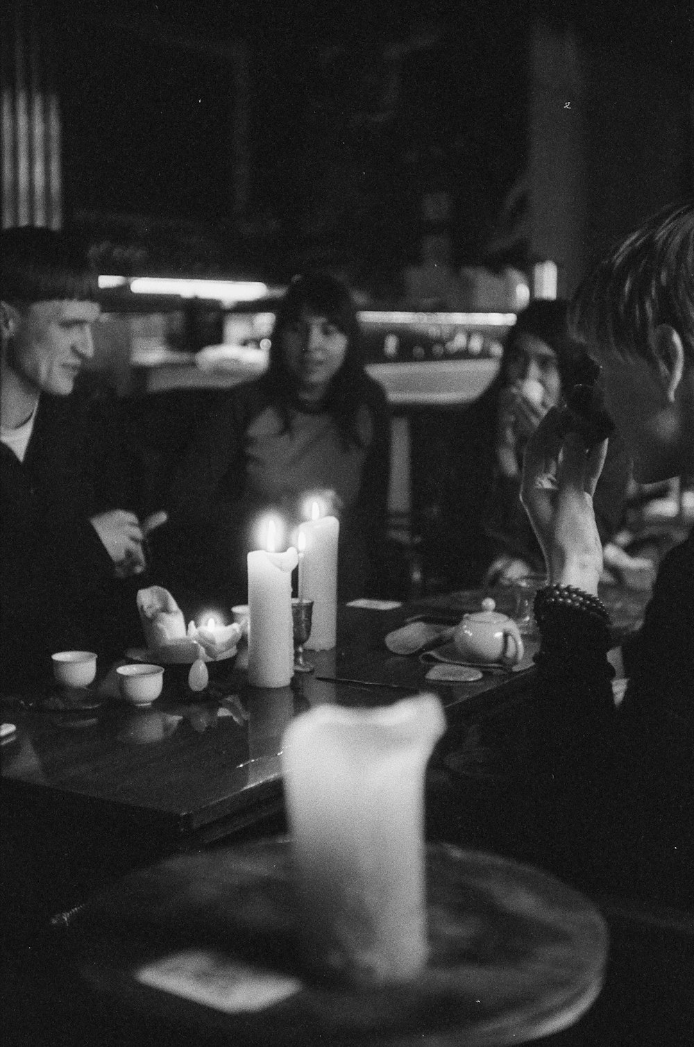 grayscale photo of man and woman sitting beside table