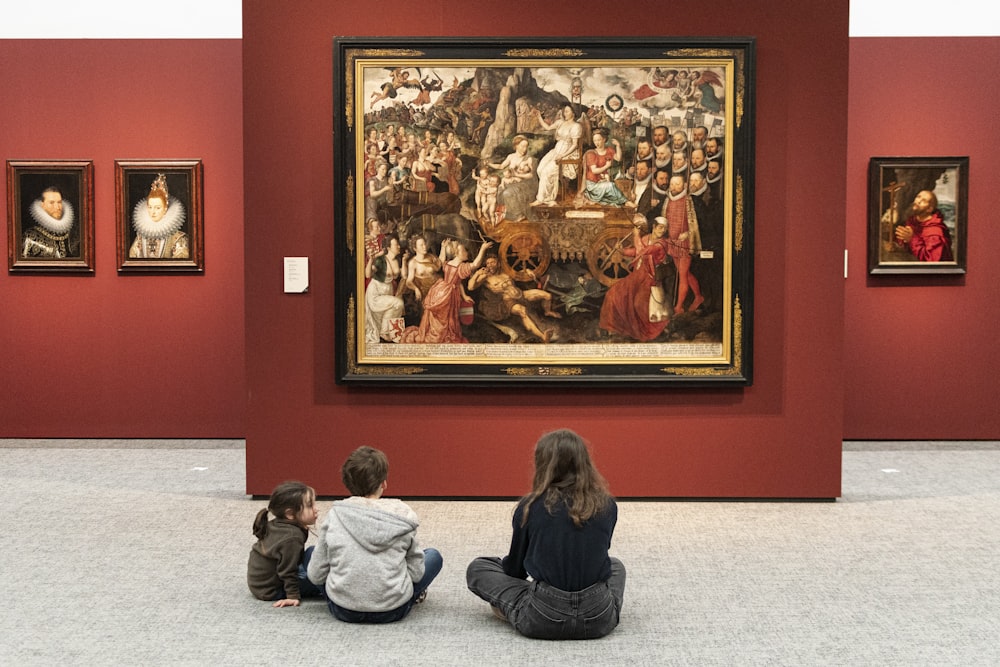 woman in black jacket sitting on floor with people sitting on floor painting