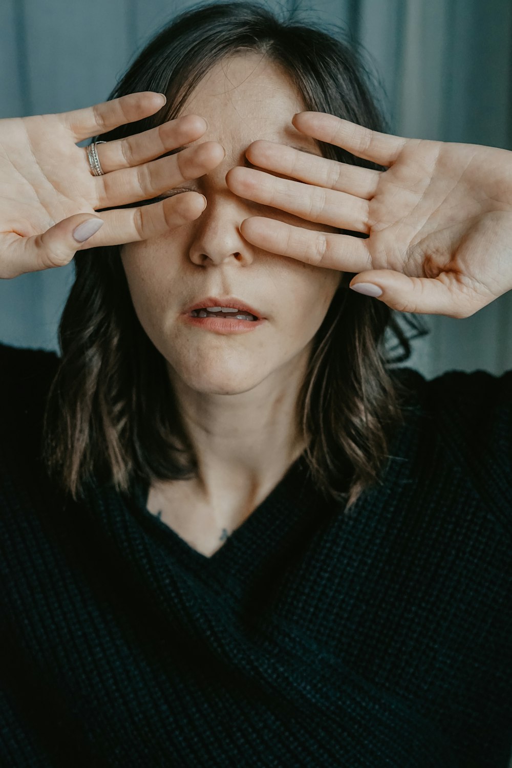 a woman covering her eyes with her hands