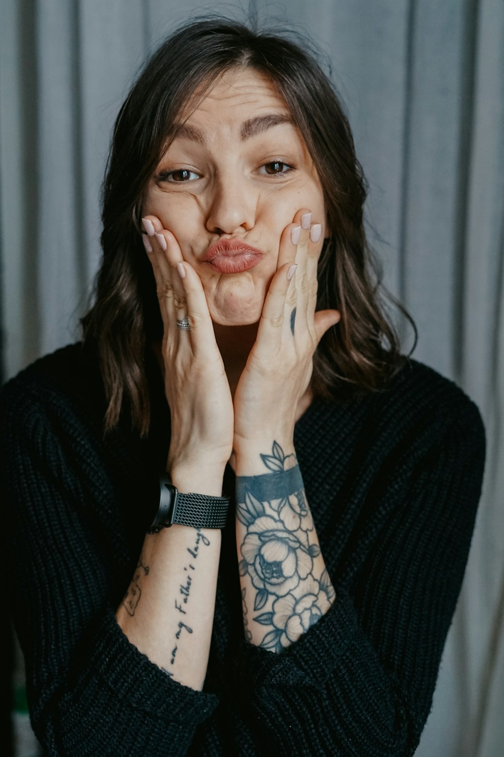 woman in black long sleeve shirt with black tattoo on her left hand